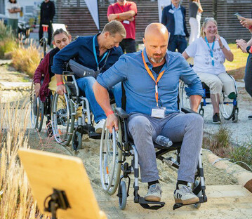 Teilnehmer konnten auf einer Rollstuhl-Teststrecke die Berollbarkeit von Sand mit eigens entwickelten Adaptern erfahren.