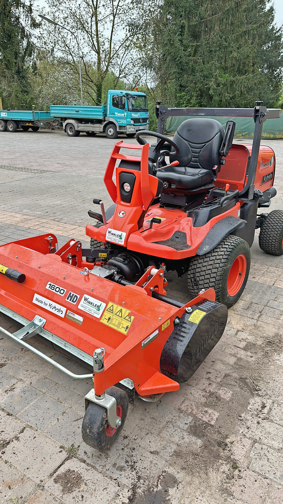 Kubota Landwirtschaftsschlepper mit Frontmulcher: Die Maschine schneidet feines Gras und kleine Strucher und walzt gleichzeitig die Grasnarbe.