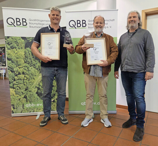 Der QBB-Vorsitzende Christian Draeger (r.) bergab den ersten Qplus Award an Snke Scheel vom Unternehmen Osbahr Garten- und Landschaftsbau (M.) und Tom Braam vom Unternehmen Opitz Grobaumverpflanzung.