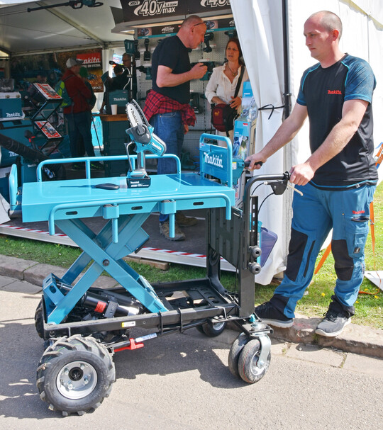Beides Akku-Systemtechnik: die handliche Astsäge DUC101 von Makita auf dem neuen Minidumper mit hochfahr- und absenkbarer Transportfläche.