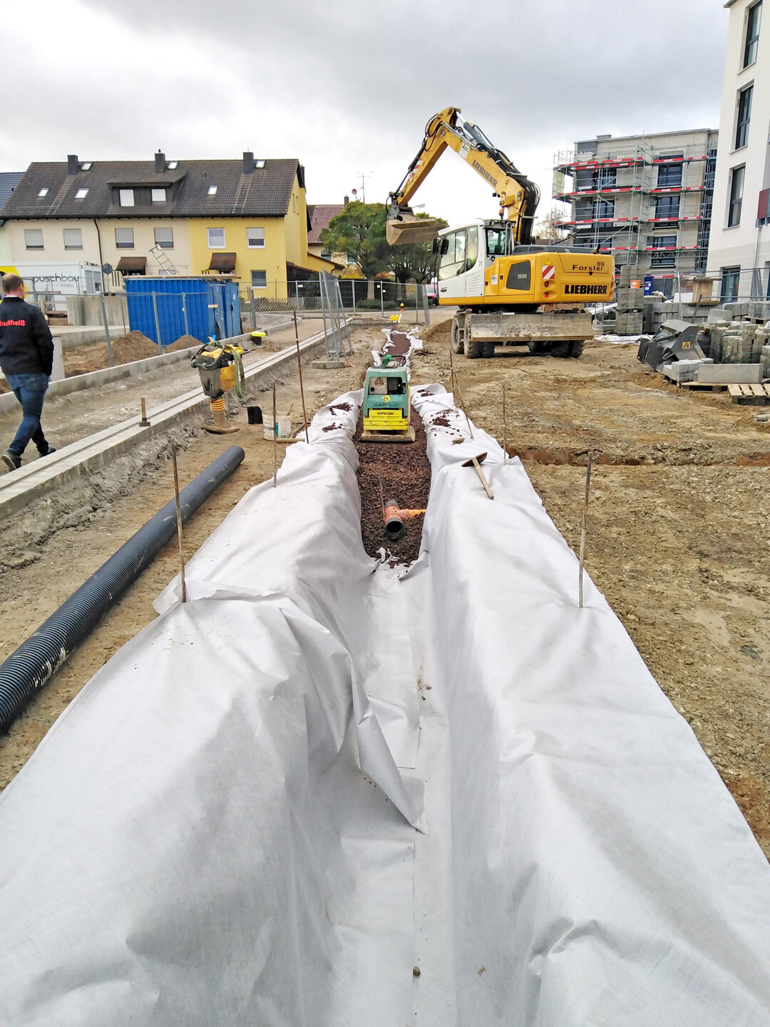 Einbau Vollsickerrohr unter der Sickerrinne. Sichtbar ist der Abzweig zur Baumgrube.