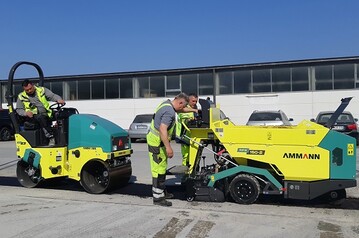 Einsatz beim Breitbandausbau in Grtringen (Baden-Wrttemberg): Eine knickgelenkte Ammann ARX 12-Aufsitzwalze verdichtet hinter dem AFW 150-2 (r.). 