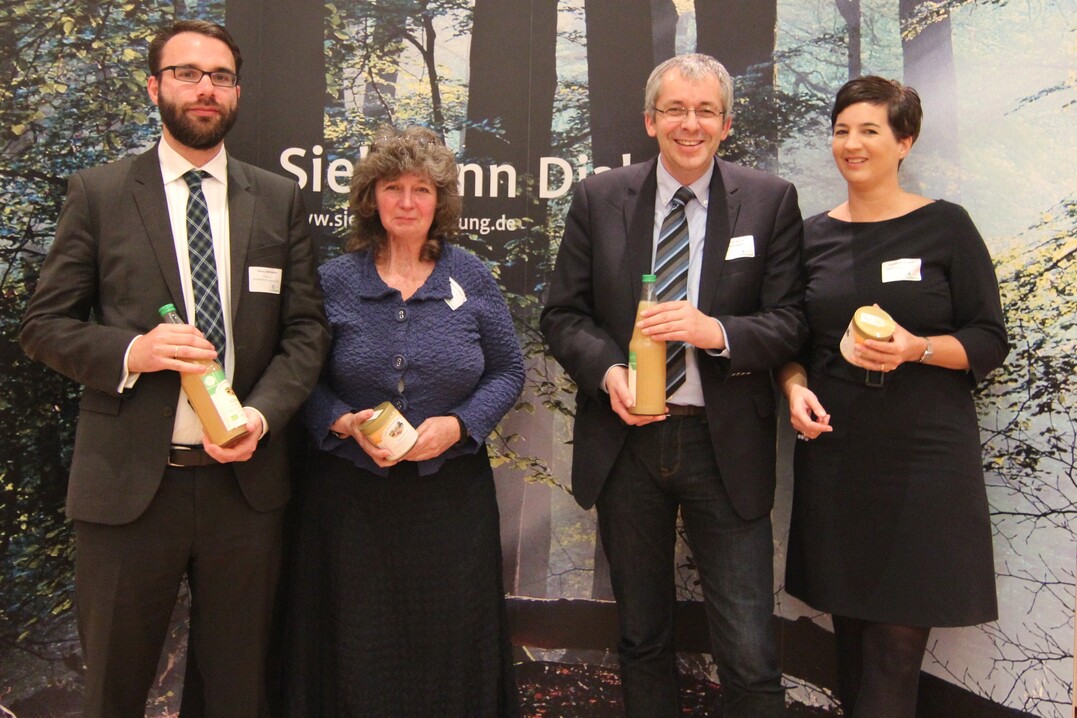 Die Diskutanten des Sielmann-Dialogs freuen sich über ein Dankeschön der Heinz Sielmann Stiftung - Apfelsaft und Honig vom Gut Herbigshagen. Abgebildet sind von links nach rechts: Tobias Hartmann, KPMG AG Wirtschaftsprüfungsgesellschaft Marion Hammerl, Global Nature Fund Prof. Dr. Bernd Hansjürgens, Helmholtz-Zentrum für Umweltforschung GmbH Carolin Boßmeyer, ‘Biodiversity in Good Company‘ Initiative e.V. Weiterer Podiumsteilnehmer: Dr. Kilian Delbrück, Bundesministerium für Umwelt, Naturschutz, Bau und Reaktorsicherheit