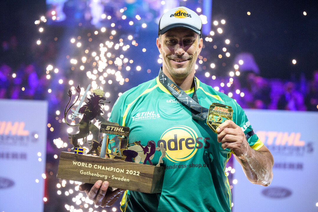 Brad De Losa zeigt stolz die Trophe des TIMBERSPORTS Einzel-Weltmeisters 2022.